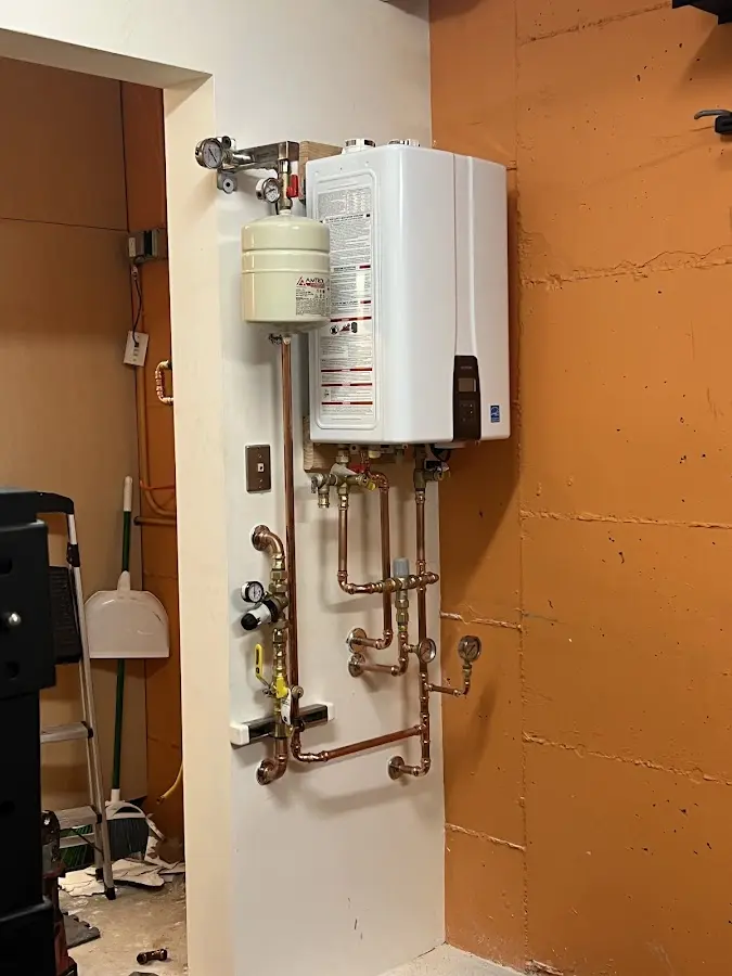 Plumbing technician inspecting water heater connections in Sherwood